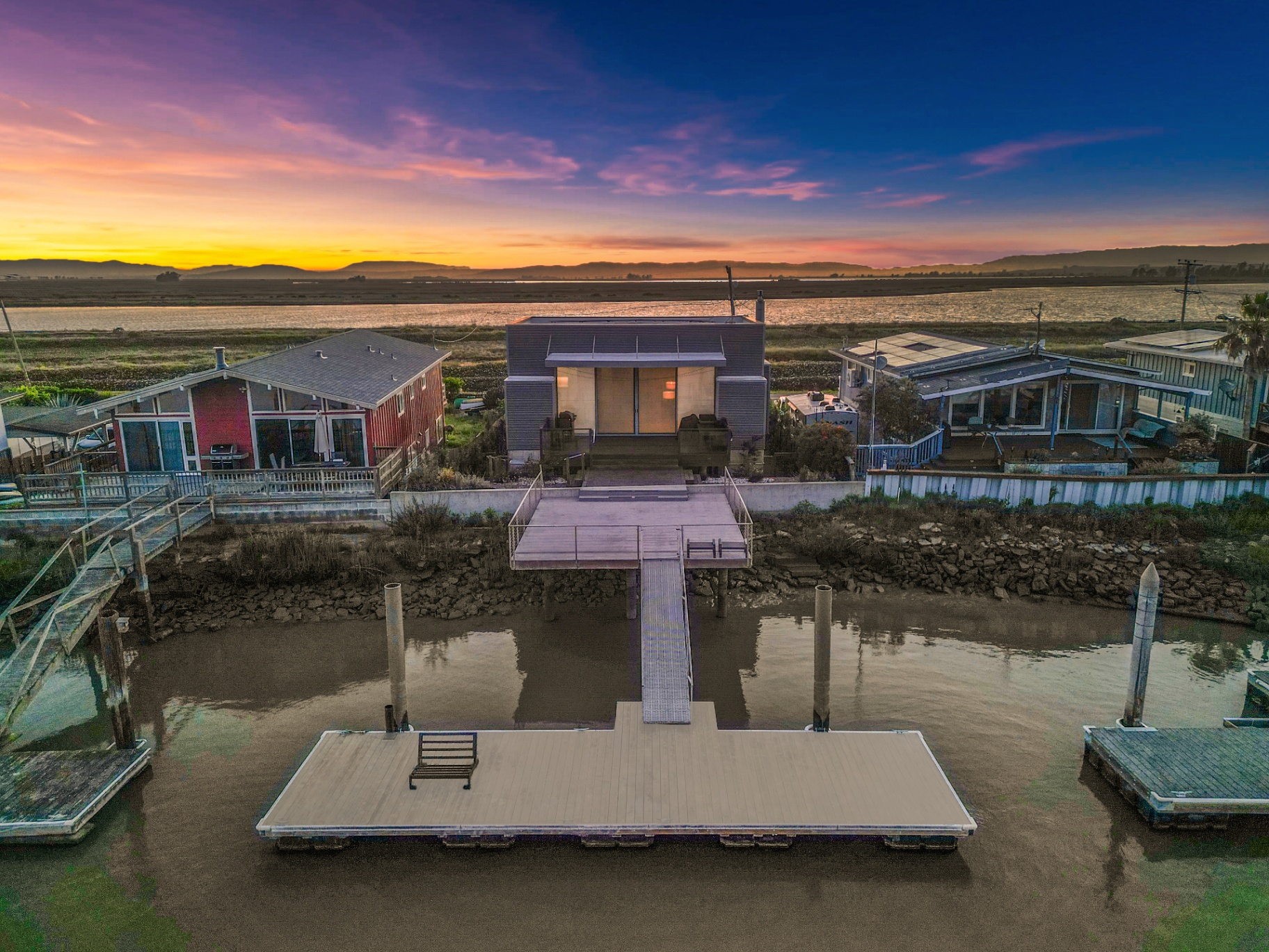 Twilight drone view of the residence and private dock